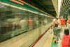 Commuters wait as a subway train passes by, capturing the hustle of urban travel.